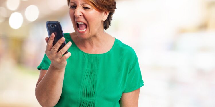 portrait of angry mature woman talking on telephone