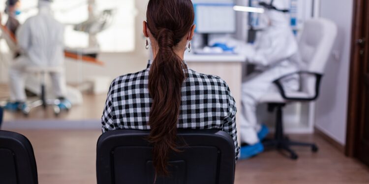 back view of woman in dentist office waiting for consultation