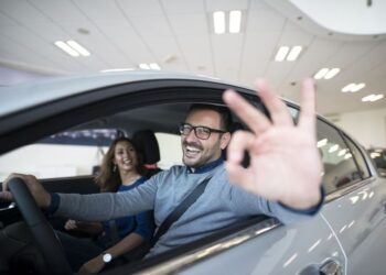 happy customer buying new car at dealership.