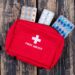 first aid kit with pills top view on a dark wooden background