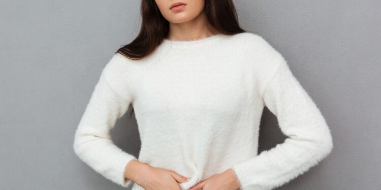 close up photo of depressed young woman with abdominal pain, loo