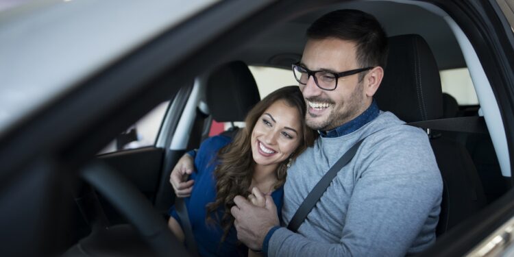 happy young couple enjoying their brand new car.