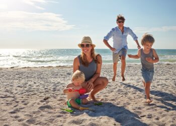happy,,parents,and,children,playing,on,the,beach,on,family