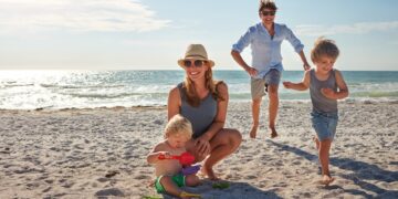 happy,,parents,and,children,playing,on,the,beach,on,family