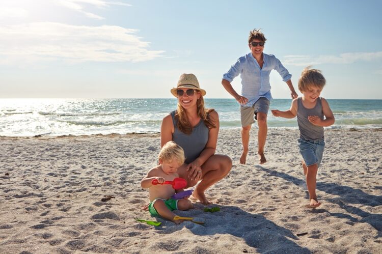 happy,,parents,and,children,playing,on,the,beach,on,family