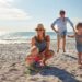 happy,,parents,and,children,playing,on,the,beach,on,family