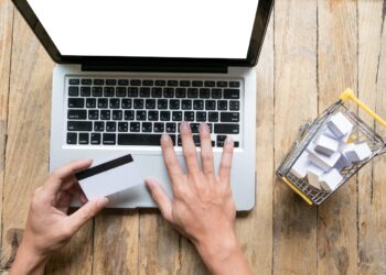 man holding credit card in hand and entering security code using