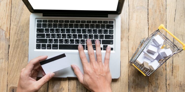 man holding credit card in hand and entering security code using